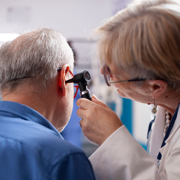 Un homme et une femme examinent attentivement une oreille.